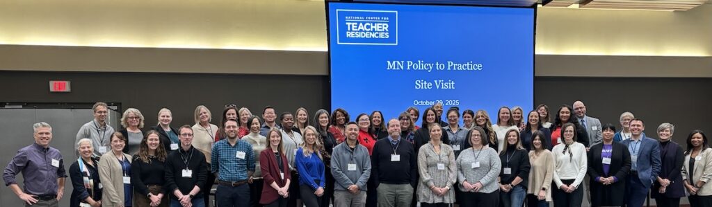 The National Center for Teacher Residencies facilitates a Policy-to-Practice Site Visit in Minnesota in October 2025. Rows of people stand in front of a presentation screen titled MN Policy to Practice Site Visit.